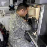 Capt. Jake Derivan, with the 3rd Civil Support Team, Pennsylvania National Guard, utilizes the Class III Glove Box onboard the analytical laboratory system during training at the combined arms collective training facility on Fort Indiantown Gap, Pa., May 14, 2014. The machine protects environmental science officers against pathogenic agents while they safely research chemical and biological substances. Credit: HollyAnn Nicom