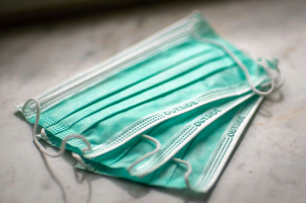 A couple of basic medical face masks laying on a table.
