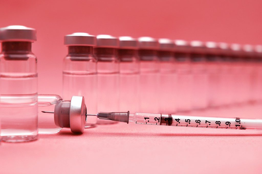 Coating the Liver’s Doorways Could Make mRNA Vaccines Safer and More Effective A row of glass vaccine vials with silver caps stands upright in a receding line, growing softer in focus toward the background. In the foreground, one vial lies on its side next to a syringe with a needle, the syringe's plunger marked with measurement increments from 0.1 to 1.0.