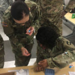 Spc. Kendra Ruiz, a medical laboratory specialist with the 1st Area Medical Laboratory, directs Sgt. Natasha Sims, a Veterinary Food Inspection Specialist also with 1st AML, on how to do thick and thin blood smears during the course. Credit: David Doubek 1st AML Operational Clinical Infectious Disease Course